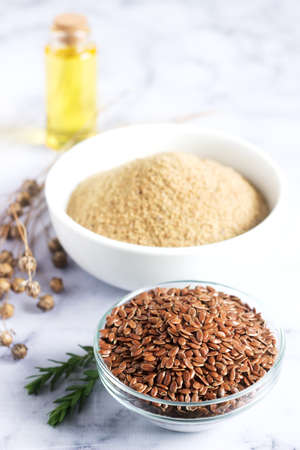Flax seeds, flax flour, oil with sprouts and flax seed boxes on a light background. Selective focus.の写真素材