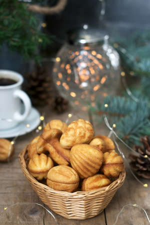 Homemade shortbread cookies in various shapes, filled with caramel on the background of fir branches and garlands.の写真素材