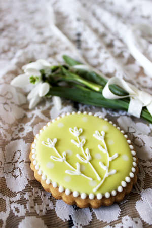 Spring composition of a bouquet of snowdrops and painted gingerbread. Rustic style, selective focus.