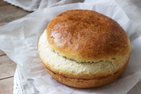 Fresh homemade wheat yeast bread on a linen tablecloth. Rustic style, selective focus.