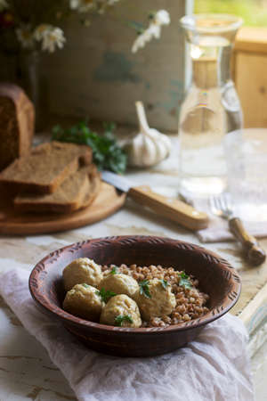 Meatballs in sour cream sauce, served with buckwheat porridge, bread and garlic. Rustic style.の写真素材