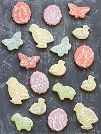 Easter gingerbread cookies decorated with various ornaments on a gray background.