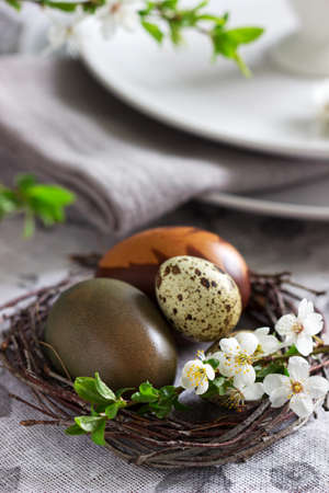 Decorated Easter table with blooming cherry plum. Selective focus.