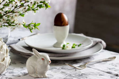 Decorated Easter table with blooming cherry plum. Selective focus.