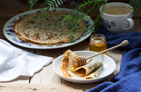 Nettle and spinach pancakes served with honey and coffee. Rustic style, selective focus.の写真素材