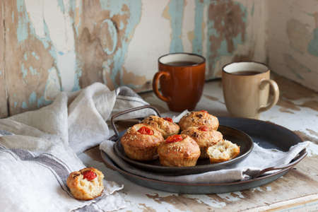 Muffins with cheese, cottage cheese and tomatoes, served with tea. Selective focus.の写真素材
