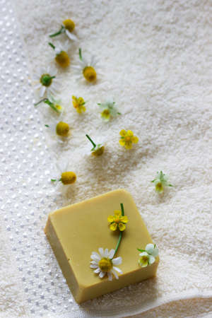 Handmade soap with medicinal herbs, flowers and a towel.の写真素材