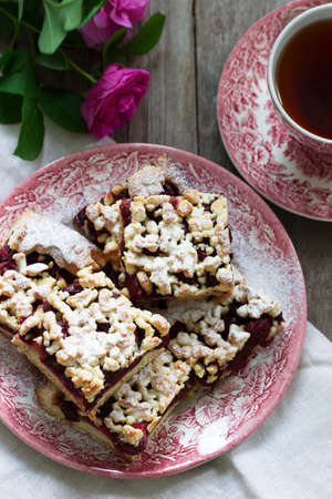 Sweet cake with cherry rose arenas and streusel on a wooden background. Rustic style, selective focus.の写真素材