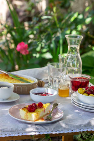 Breakfast in the garden from casseroles, berries, sauces and drinks. Rustic style, selective focus.の写真素材