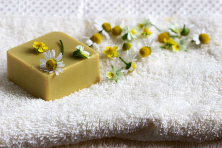 Handmade soap with medicinal herbs, flowers and a towel.の写真素材