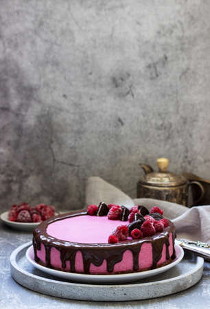 Currant mousse cake decorated with pieces of cookies and raspberries. Selective focus.の写真素材