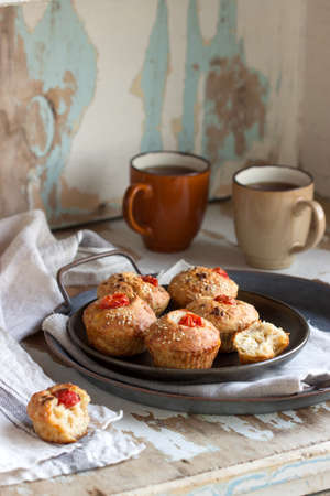 Muffins with cheese, cottage cheese and tomatoes, served with tea. Selective focus.の写真素材