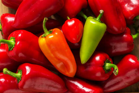 Sweet peppers of various colors on a wooden surface. Selective focus.の写真素材