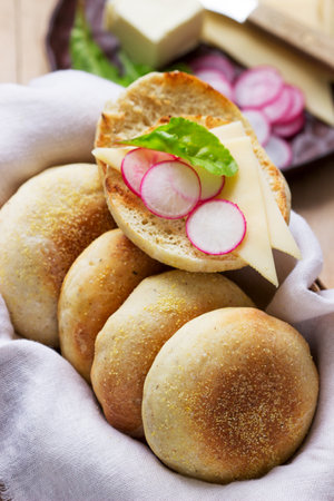 English muffins from whole grain and flax meal, filed with cheese and radish. Rustic style, selective focus.の写真素材