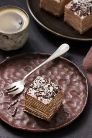 Chocolate cake with sour cream, served with coffee. Selective focus.