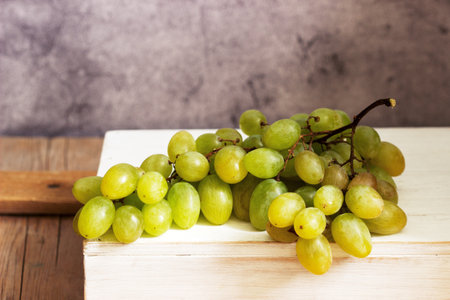 Amber bunch of grapes on a gray concrete background. Selective focus.の写真素材
