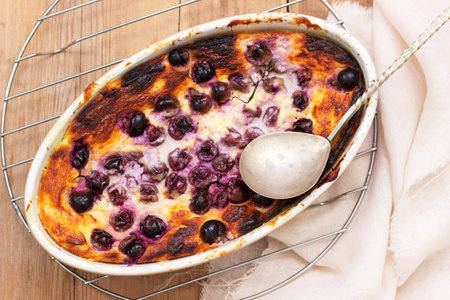 Delicate curd casserole with grapes in a ceramic form on a wooden surface. Selective focus.の写真素材