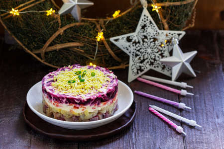 Dressed herring, raditional Soviet festive salad of herring and vegetables in a New Year's decoration. Rustic style.の写真素材