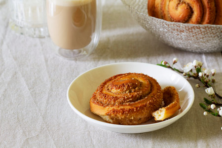 Cinnamon buns with nuts served with cappuccino on a linen tablecloth, useful breakfast. Rustic style, selective focus.の写真素材