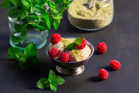 Ice cream with raspberries and mint in an iron bowl on a concrete surface. Selective focus.の写真素材