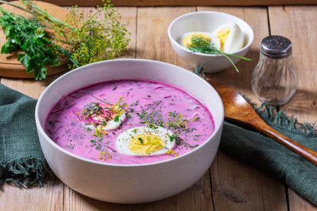 Traditional summer cold beetroot soup with cucumber, egg and sour cream on a wooden background. Rustic style, selective focus.の写真素材