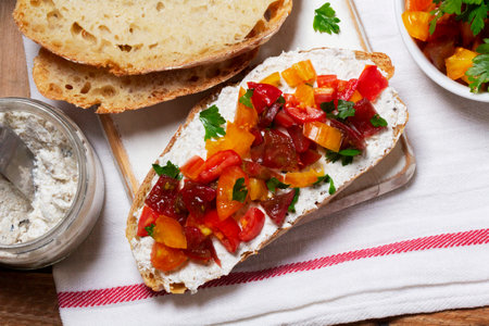 Bruschetta from homemade bread with cottage cheese and sprat pate and tomatoes on a wooden background. Rustic style, selective focus.の写真素材