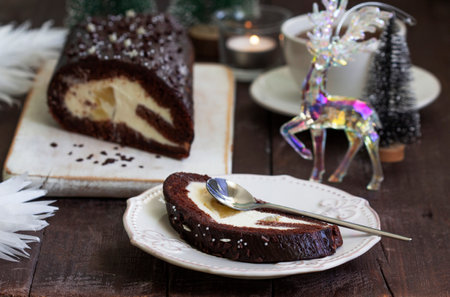 Chocolate roll stuffed with butter cream and pineapple on a Christmas background. Rustic style, selective focus.の写真素材