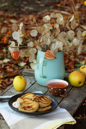 Whole wheat apple pancakes served with tea in the garden. Rustic style, selective focus.の写真素材