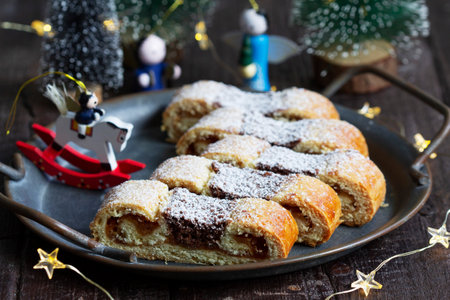 Grandfather's mustache cookies made from shortcrust pastry filled with nuts, jam and cocoa, Christmas toys and garland on a wooden background. Christmas or New Year concept, selective focus.の写真素材