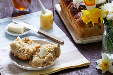 Cross buns served with butter, honey and tea. Easter breakfast.