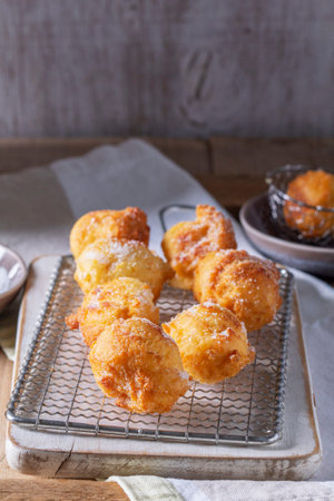 Curd donuts with sugar served with tea or coffee on a light wooden background. Rustic style.