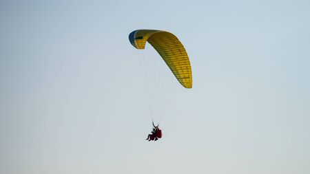 Paraglider with passanger flying in the blue sky. Copyspace for text.
