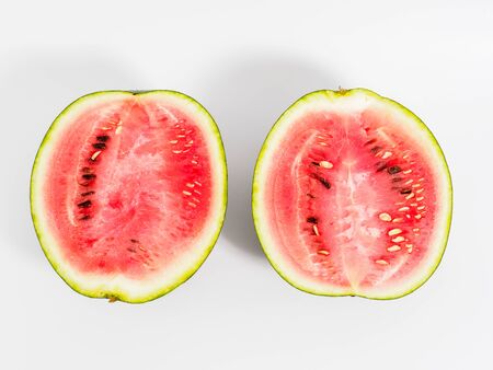 Halved watermelon on white background. Isolated parts of watermelon with yellow spot on the side. Top view and copyspace for text.の写真素材