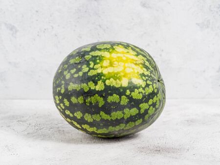 Fresh watermelon on gray background. Isolated whole watermelon with yellow spot on the side. Copyspace for text.の写真素材