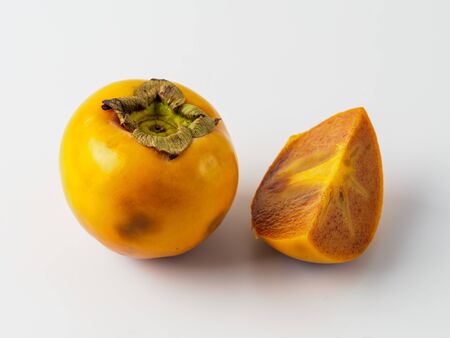 Single persimmon isolated on white background. Fresh fruit of diospyros tree that grows in tropical lands. Copyspace for text.の写真素材