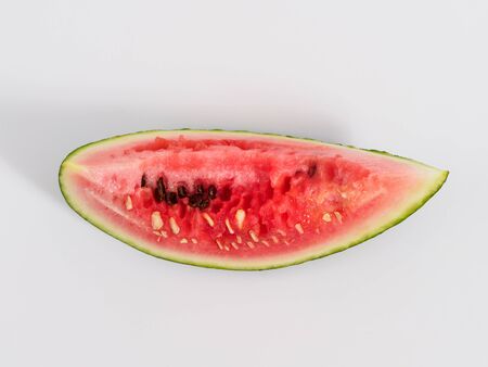 Bitten slice of watermelon on white background. Isolated part of watermelon with yellow spot on the side. Top view and copyspace for text.の写真素材