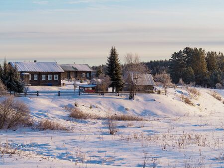 Winter view of Russian village. Beautiful landscape with house of wood and forest on the background.の写真素材