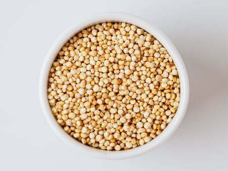 Quinoa seeds isolated on white background. Natural product in the plate with copyspace for text.の写真素材