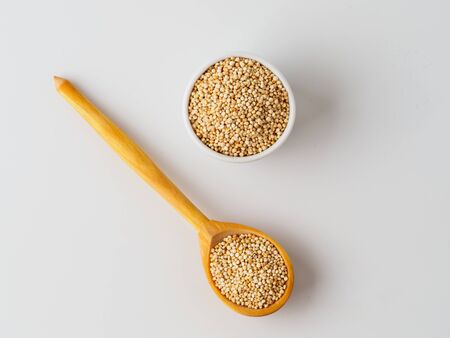 Quinoa seeds isolated on white background. Natural product in spoon and plate with copyspace for text.の写真素材