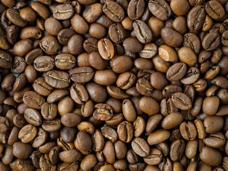 Carpet of roasted coffee beans. Mix of arabica and robusta beans in closeup view.の写真素材