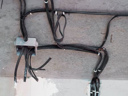 Electric installation on the ceiling. Cable boxes with wires on concrete wall.の写真素材