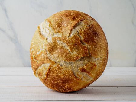 Loaf of bread on wooden background. Natural domestic bakery. Copyspace for text.の写真素材