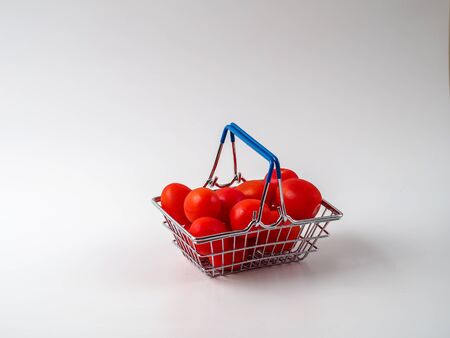 Shopping cart with tomatoes on white background.の写真素材