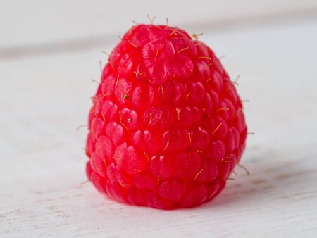 Fresh raspberry on wooden background. Macro view of single berry.の写真素材