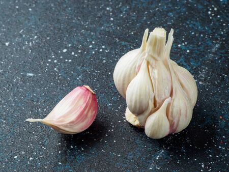 Head of garlic on dark background with one clove separate from head. Copyspace for text.の写真素材