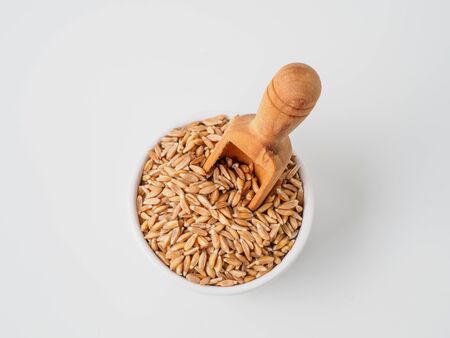 Spelt in the bowl isolated on white background. Healthy diet organic food. Copyspace for text.の写真素材