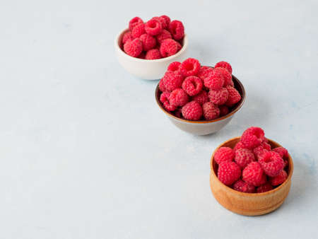 Assorted fresh raspberry in different plates.の写真素材