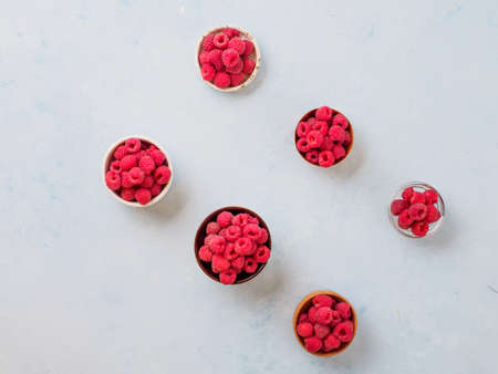 Assorted fresh raspberry in different plates.の写真素材