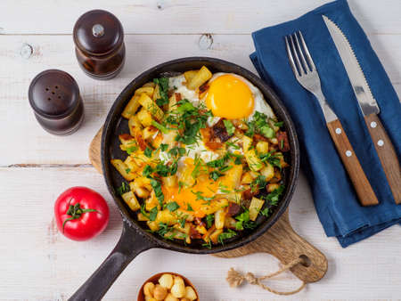 Fried eggs with potato in cast iron pan.の写真素材