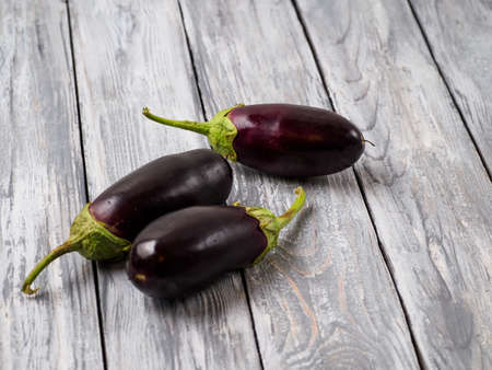 Young eggplants on wooden rustic background.の写真素材